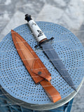 Handmade Damascus steel dagger knife with intricate pattern, featuring a polished blade and detailed handle from Knives Gear Garage.