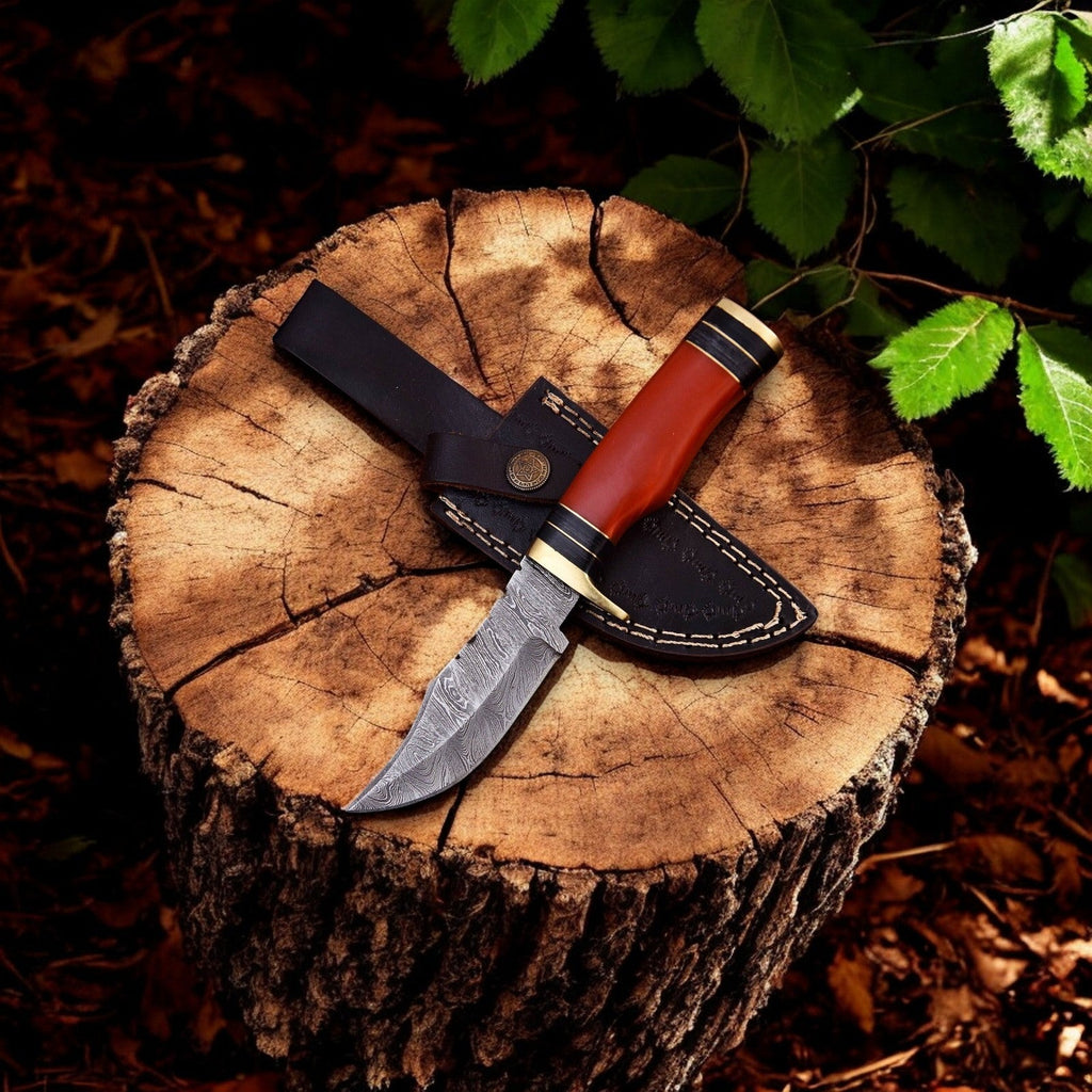Handmade Damascus hunting knife with epoxy resin handle, featuring a sharp blade and polished wood accents.