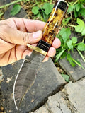 Handmade Damascus hunting knife with epoxy resin handle, featuring a detailed blade and ergonomic grip for outdoor use.