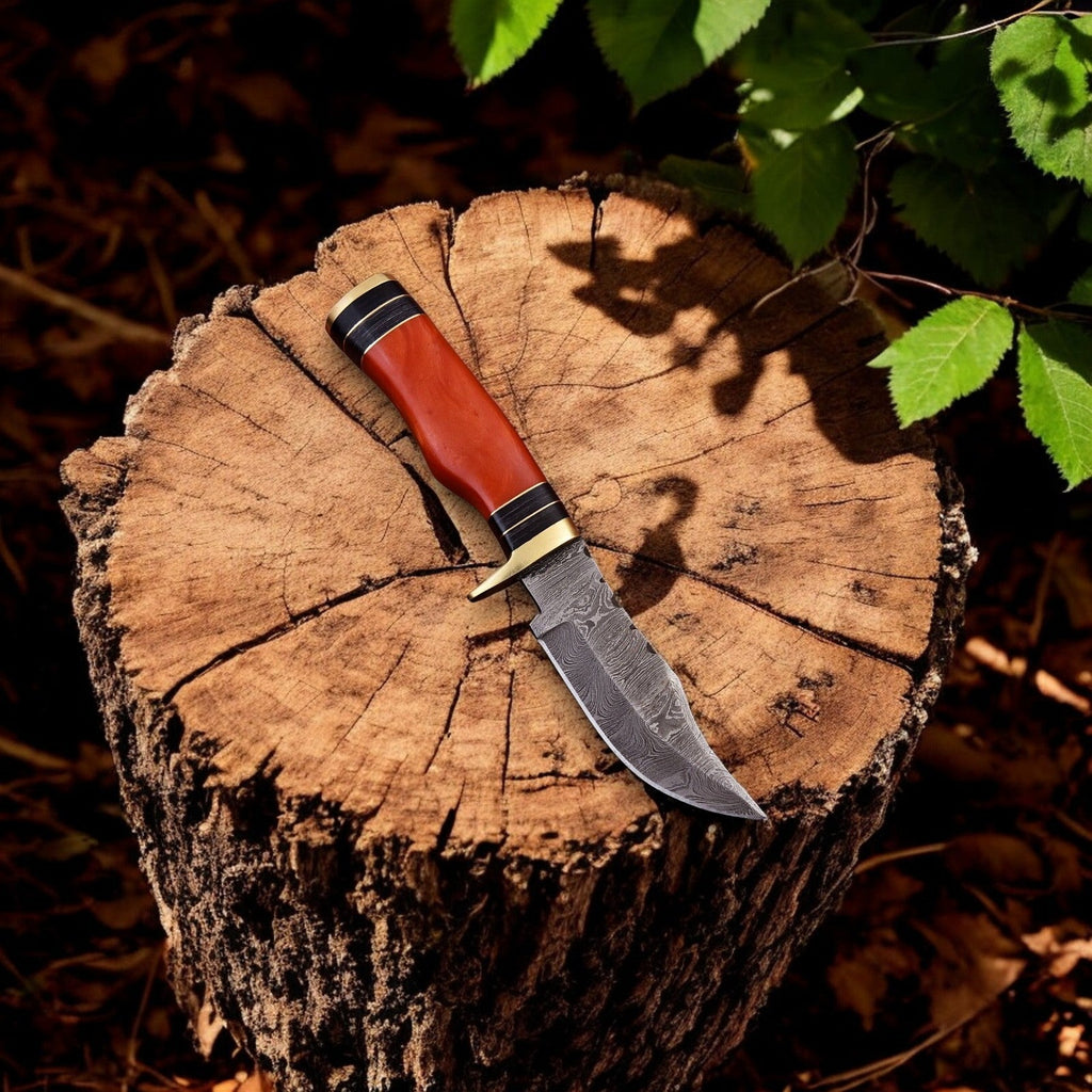 Handmade Damascus hunting knife with epoxy resin handle, featuring a patterned steel blade and ergonomic grip for outdoor use.