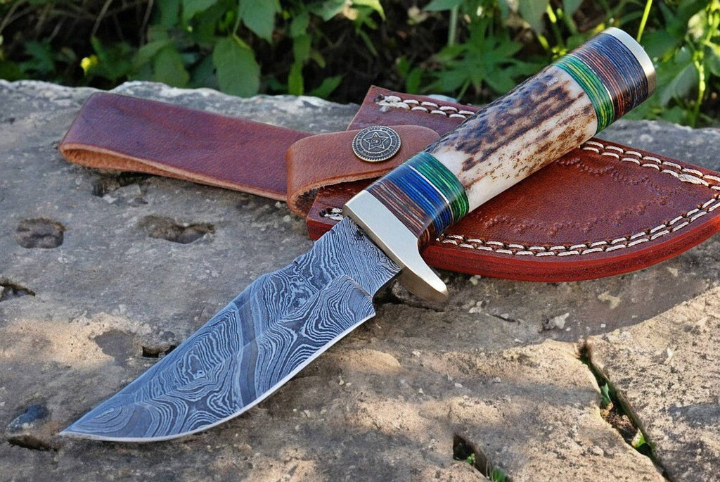 Custom handmade hunting knife with Damascus steel blade, featuring a polished handle and detailed craftsmanship.