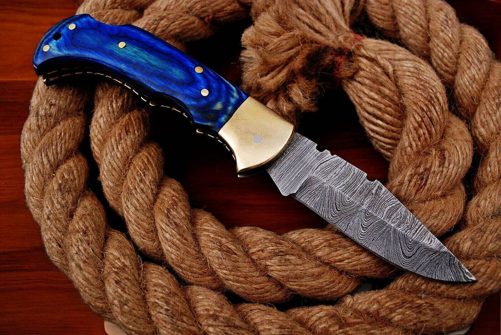 Custom handmade Damascus pocket knife with blue exotic wood handle, showcasing intricate Damascus steel blade and polished finish.