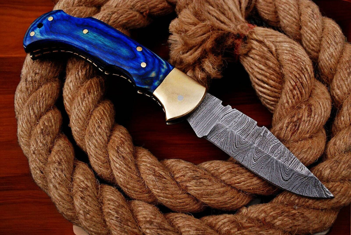 Custom handmade Damascus pocket knife with blue exotic wood handle, showcasing intricate Damascus steel blade and polished finish.
