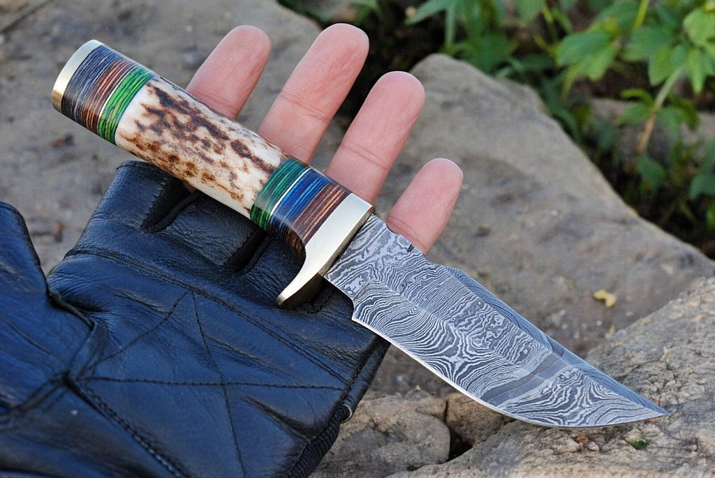 Custom handmade hunting knife with Damascus steel blade, featuring a leather handle and detailed craftsmanship.