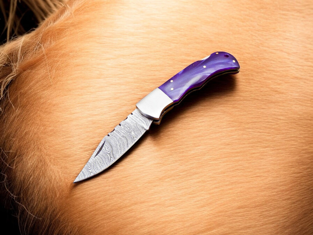 Custom Handmade Damascus pocket knife with a colored bone handle and intricate blade design from Damascus Knife Store.