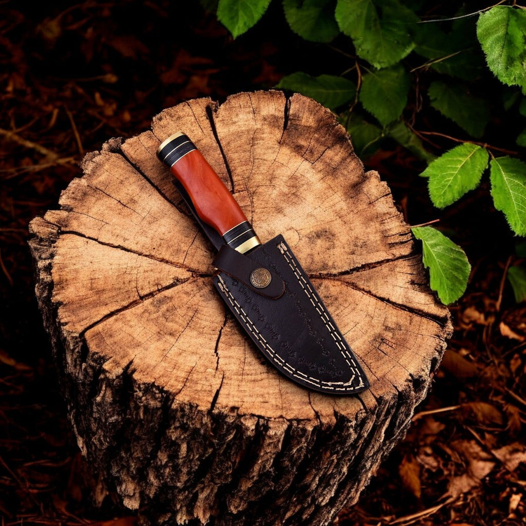 Handmade Damascus hunting knife with epoxy resin handle and intricate patterning, displayed on a neutral background.