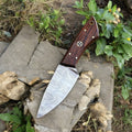 Handmade Damascus hunting knife with a polished rosewood handle and intricate blade pattern, crafted for outdoor use.