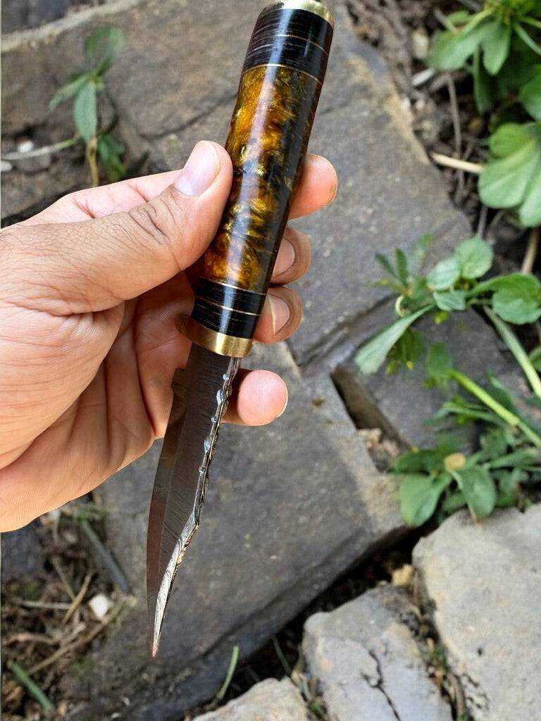 Handmade Damascus hunting knife with epoxy resin handle, featuring a sharp blade and intricate Damascus pattern.