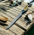 Custom handmade Damascus fillet knife with 12.5-inch blade and leather sheath, showcasing the intricate Damascus steel pattern.