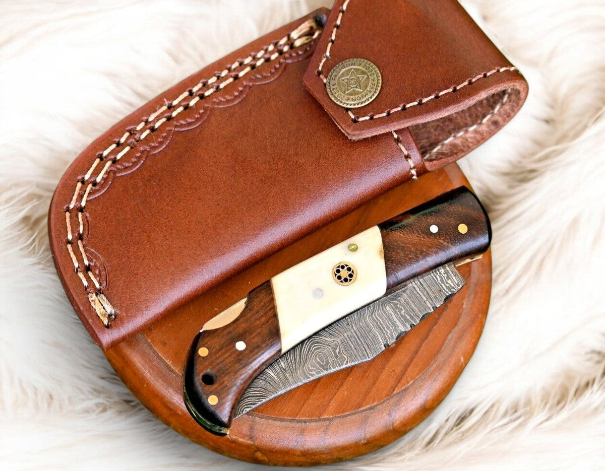 Handmade Damascus Steel pocket knife with rosewood and bone handle, featuring intricate blade patterns and detailed craftsmanship.