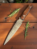 Custom handmade Damascus hunting knife with a wood handle, featuring a patterned steel blade and ergonomic wooden grip.