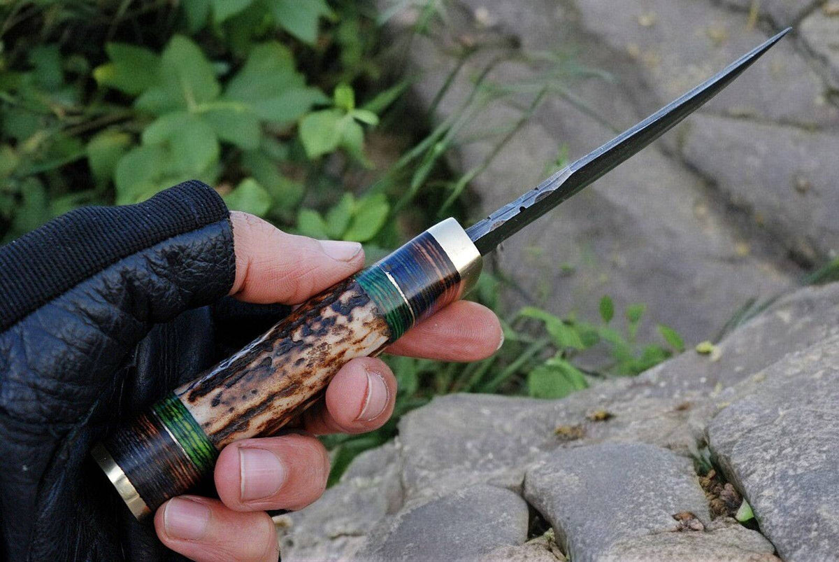 Handmade Damascus steel hunting knife with a detailed handle and custom blade, displayed on a neutral background.