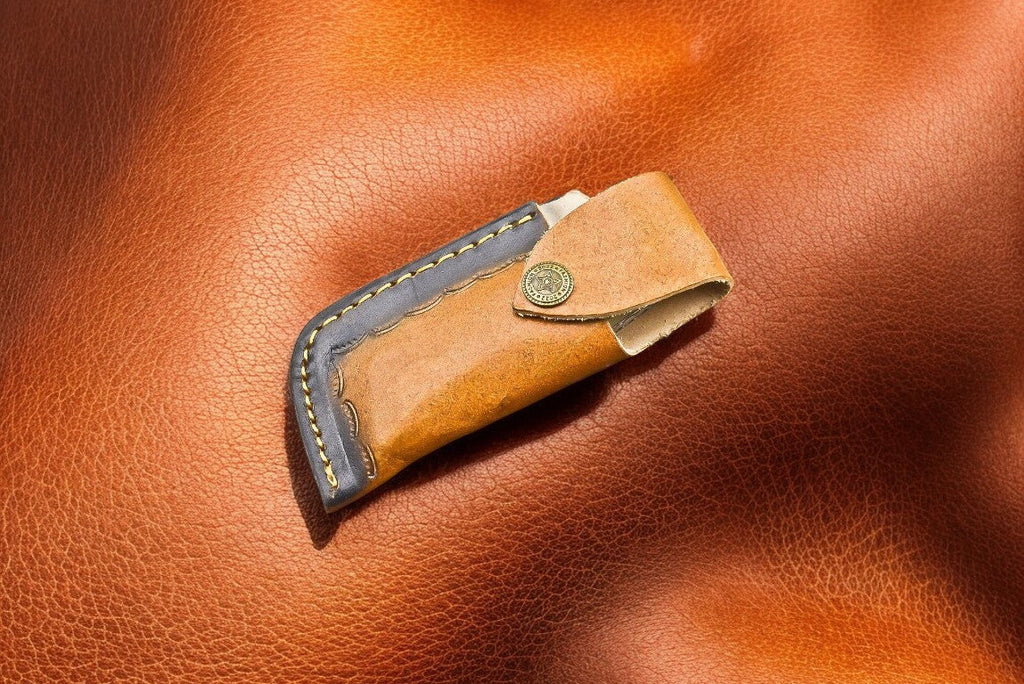 Handmade Damascus pocket knife with bone and buffalo horn handle, featuring intricate blade pattern and natural handle materials.