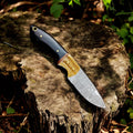 Handmade Damascus hunting knife with buffalo horn handle and antler accents, showcasing intricate Damascus steel pattern.