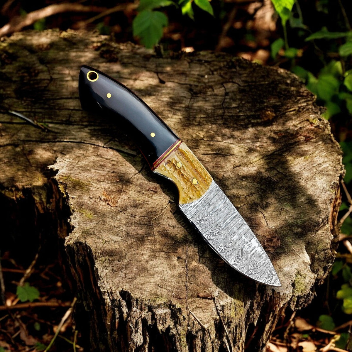 Handmade Damascus hunting knife with buffalo horn handle and antler accents, showcasing intricate Damascus steel pattern.