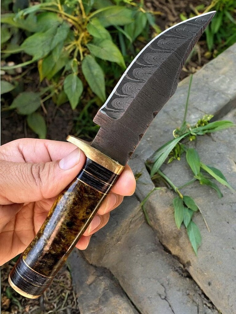 Handmade Damascus hunting knife with epoxy resin handle, detailed blade design, and textured grip from Damascus Knife Store.