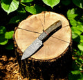 Handmade Damascus hunting knife with an exotic wood handle, featuring a sharp blade and detailed craftsmanship.