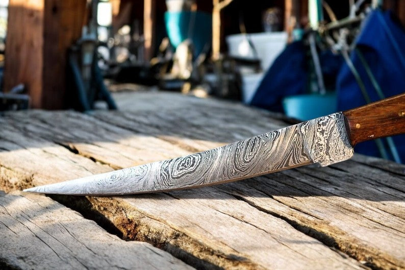 Custom handmade Damascus fillet knife with 13-inch blade, featuring a bone and wood handle, displayed on a neutral background.