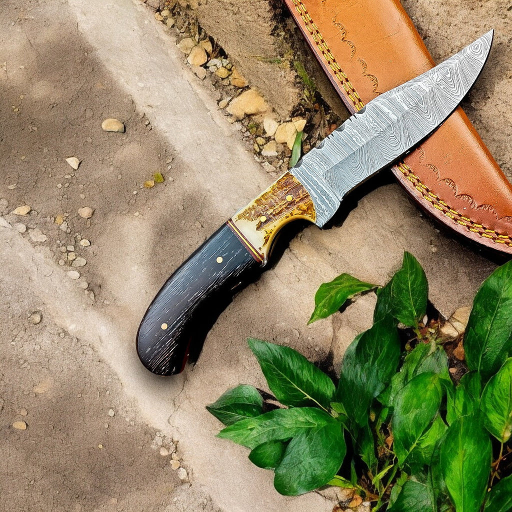 Handmade Damascus hunting knife with a wenge and antler handle, featuring a sharp blade and detailed craftsmanship.
