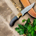 Handmade Damascus hunting knife with a wenge and antler handle, featuring a sharp blade and detailed craftsmanship.