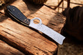 Custom handmade bull cutter knife with an exotic wood handle, featuring a Damascus Knife Store logo on the blade.