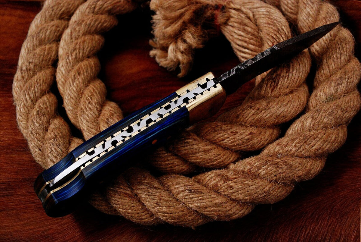 Custom handmade Damascus pocket knife with a blue exotic wood handle, featuring intricate Damascus steel blade details.