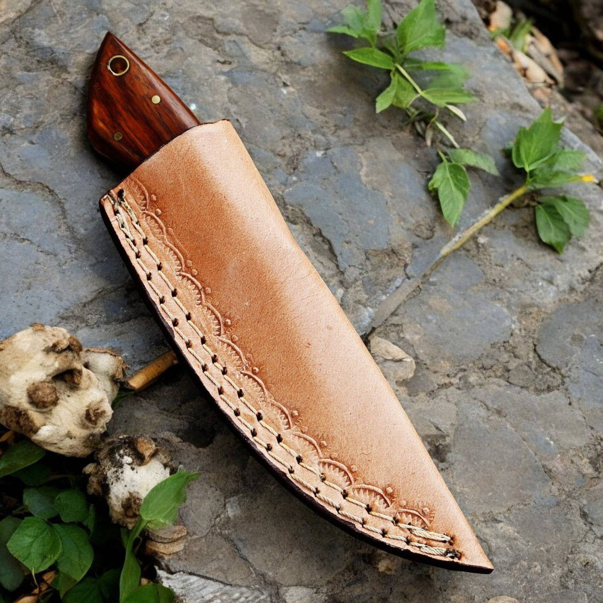 Handmade Damascus hunting knife with a polished rosewood handle and intricate blade pattern, displayed on a neutral background.