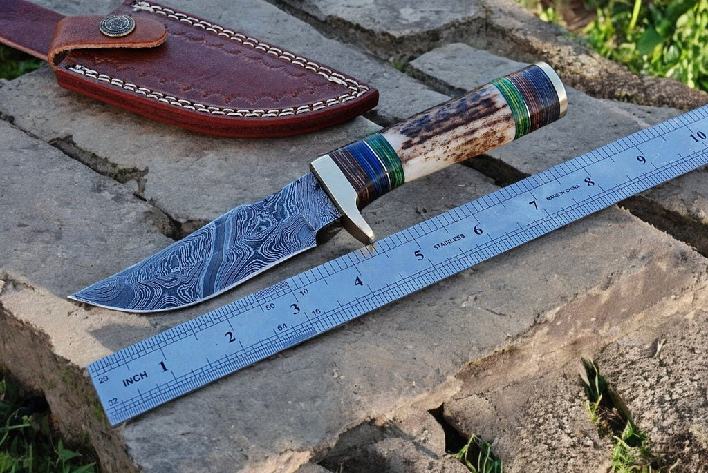 Custom handmade hunting knife with a Damascus steel blade, featuring a detailed handle and traditional craftsmanship.