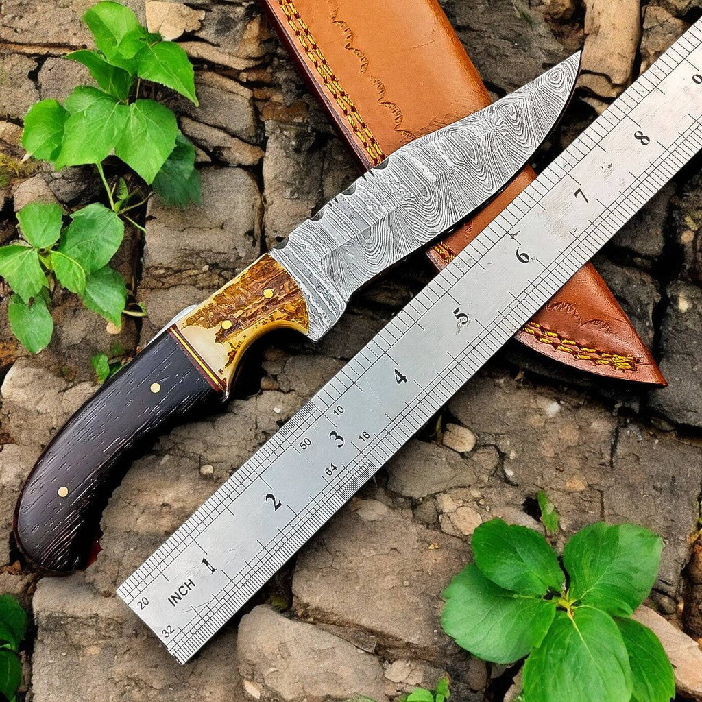 Handmade Damascus hunting knife with Wenge wood and antler handle, featuring a polished blade and detailed craftsmanship.