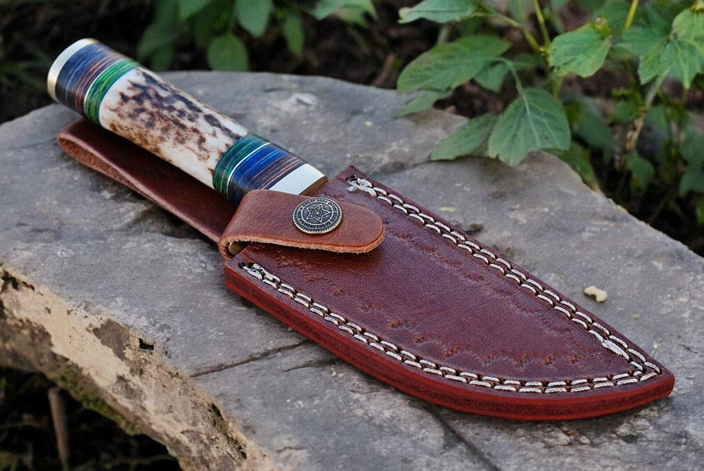 Custom handmade hunting knife with Damascus steel blade, featuring a polished wooden handle and detailed craftsmanship.