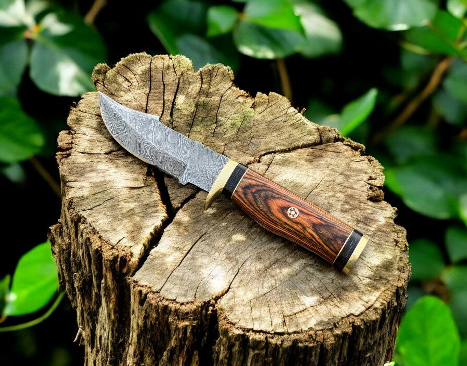 Damascus hunting knife with an intricate pattern blade and exotic wood handle, showcasing craftsmanship and detailed design.