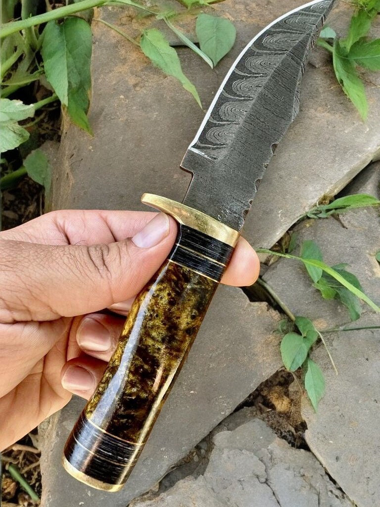 Handmade Damascus hunting knife with epoxy resin handle, featuring intricate layered steel blade and polished wood accents.
