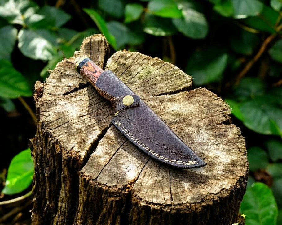 Handmade Damascus hunting knife with an exotic wood handle, showcasing a sharp blade and detailed craftsmanship.
