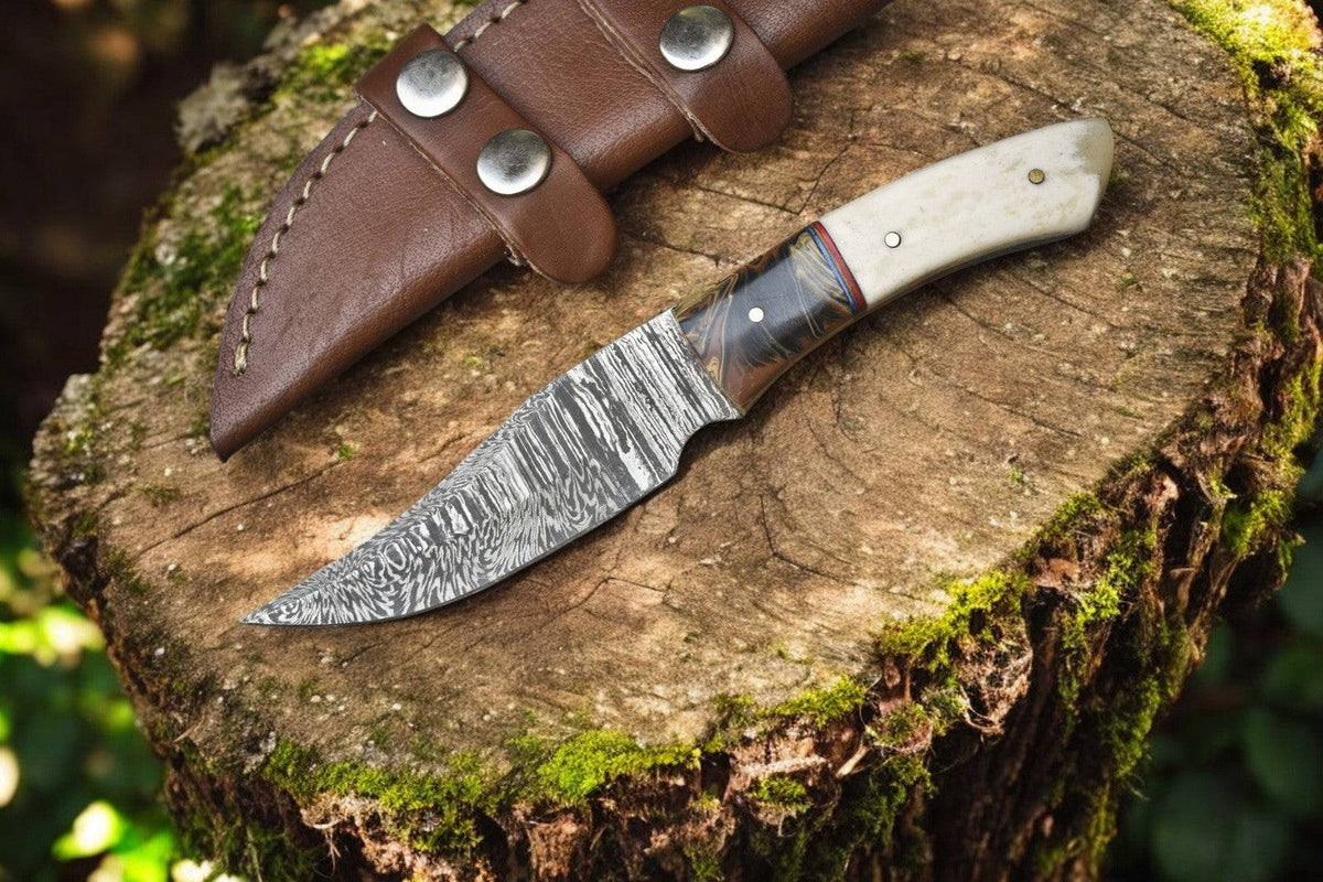 Handmade Damascus skinning knife with epoxy resin handle and bone accents, showcasing intricate Damascus steel blade.