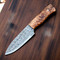 Handmade Damascus Steel Skinning Knife with leather sheath, featuring a patterned blade and ergonomic handle for hunting and outdoor use.