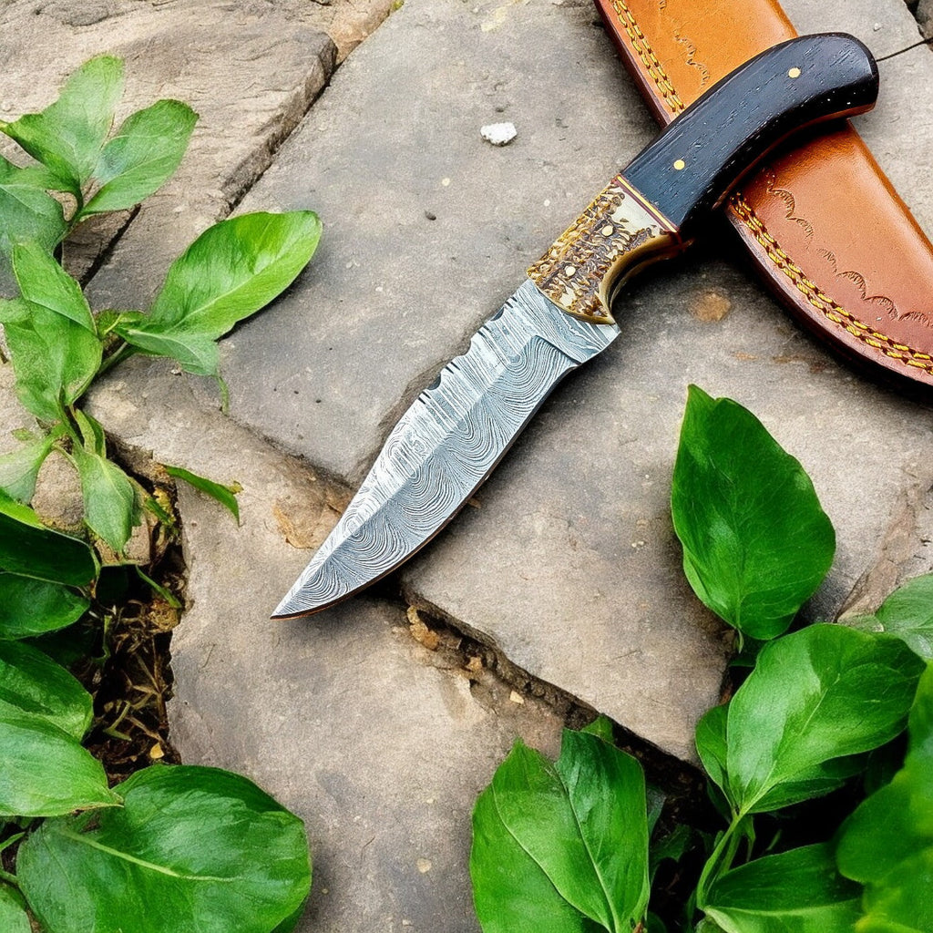 Handmade Damascus hunting knife with wenge wood and antler handle, featuring a polished blade and detailed craftsmanship.