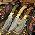 Set of three JW SteelCrafts Damascus Steel Tracker Survival Knives with camouflage handles, displayed on a black background.