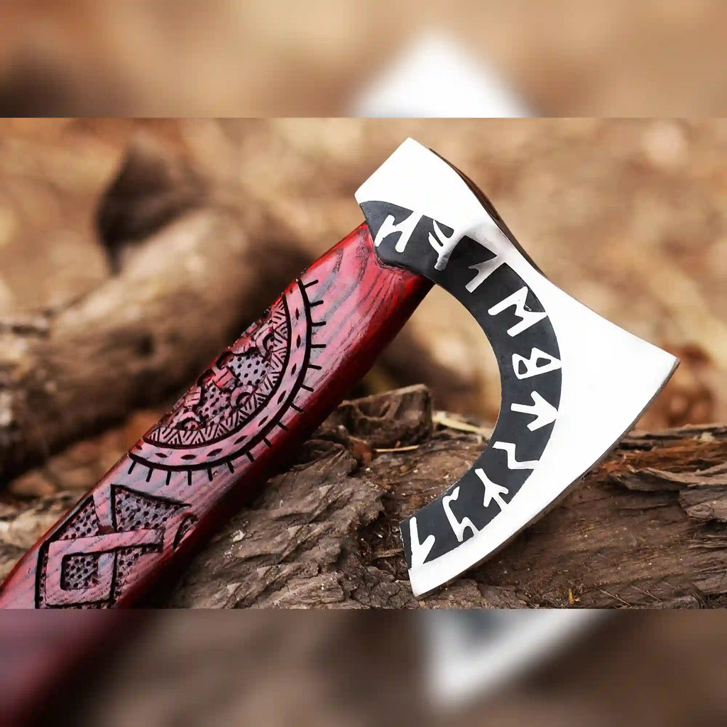 Close-up of a hand-forged Viking Runic Axe head with Norse rune carvings and a long ash handle from Malika Knives.