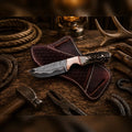 Copper Damascus cowboy knife by Sham Knives with stag horn handle and cross belt leather sheath.
