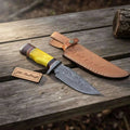 JW SteelCrafts Frontier Clip Point Bowie Knife with Damascus steel blade, yellow handle, and leather sheath.